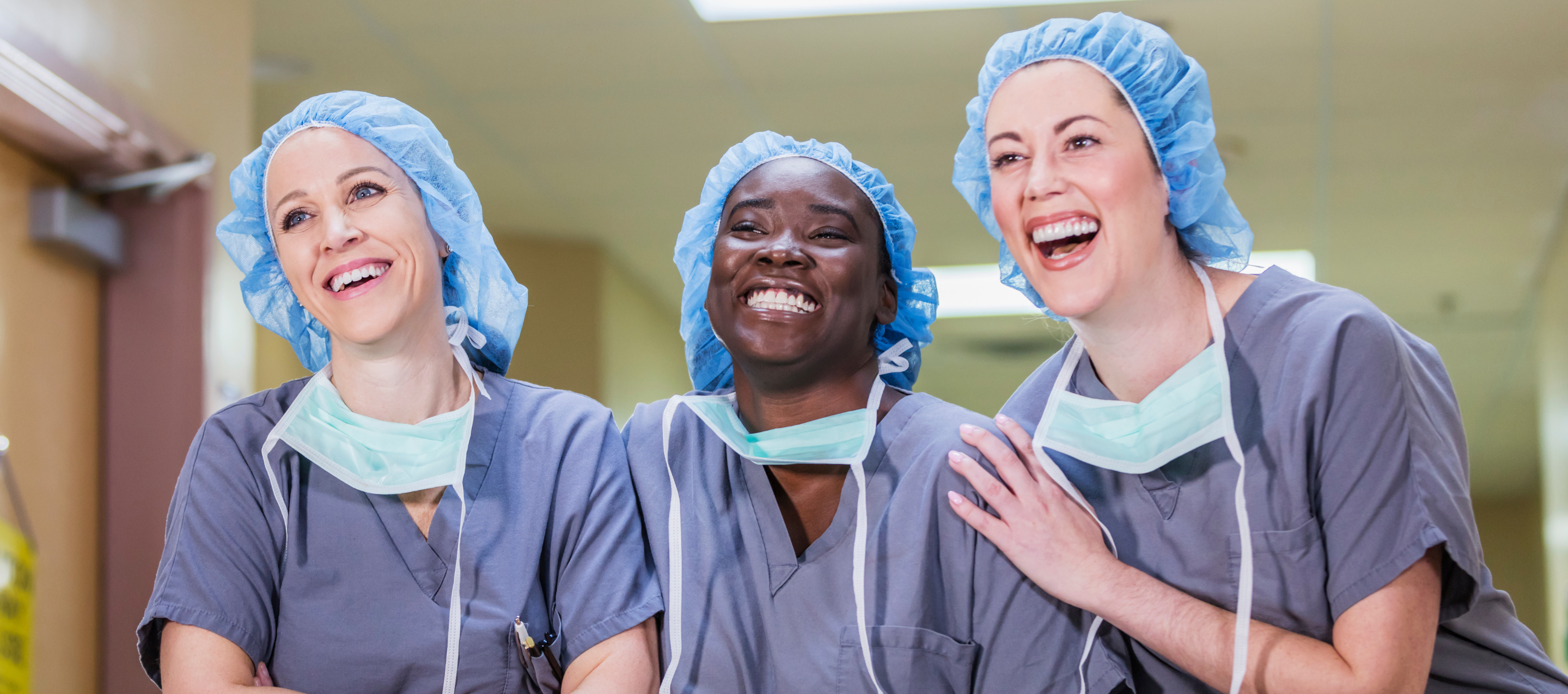 Three female hospital clinicians laughing together