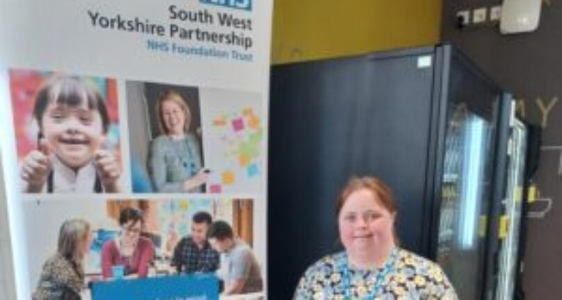 Image of Cath Horbury, Peer Support Worker, next to pull-up banner