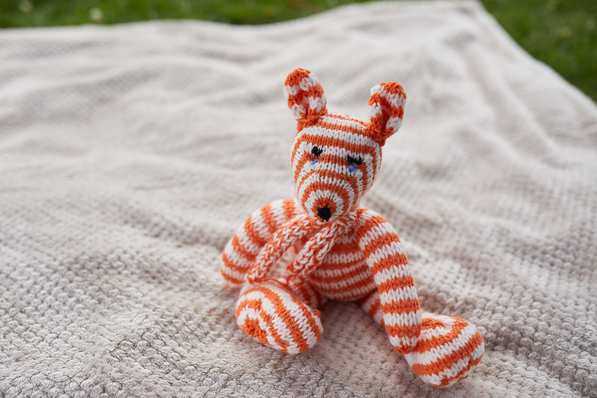 Image of an orange and white knitted bear.