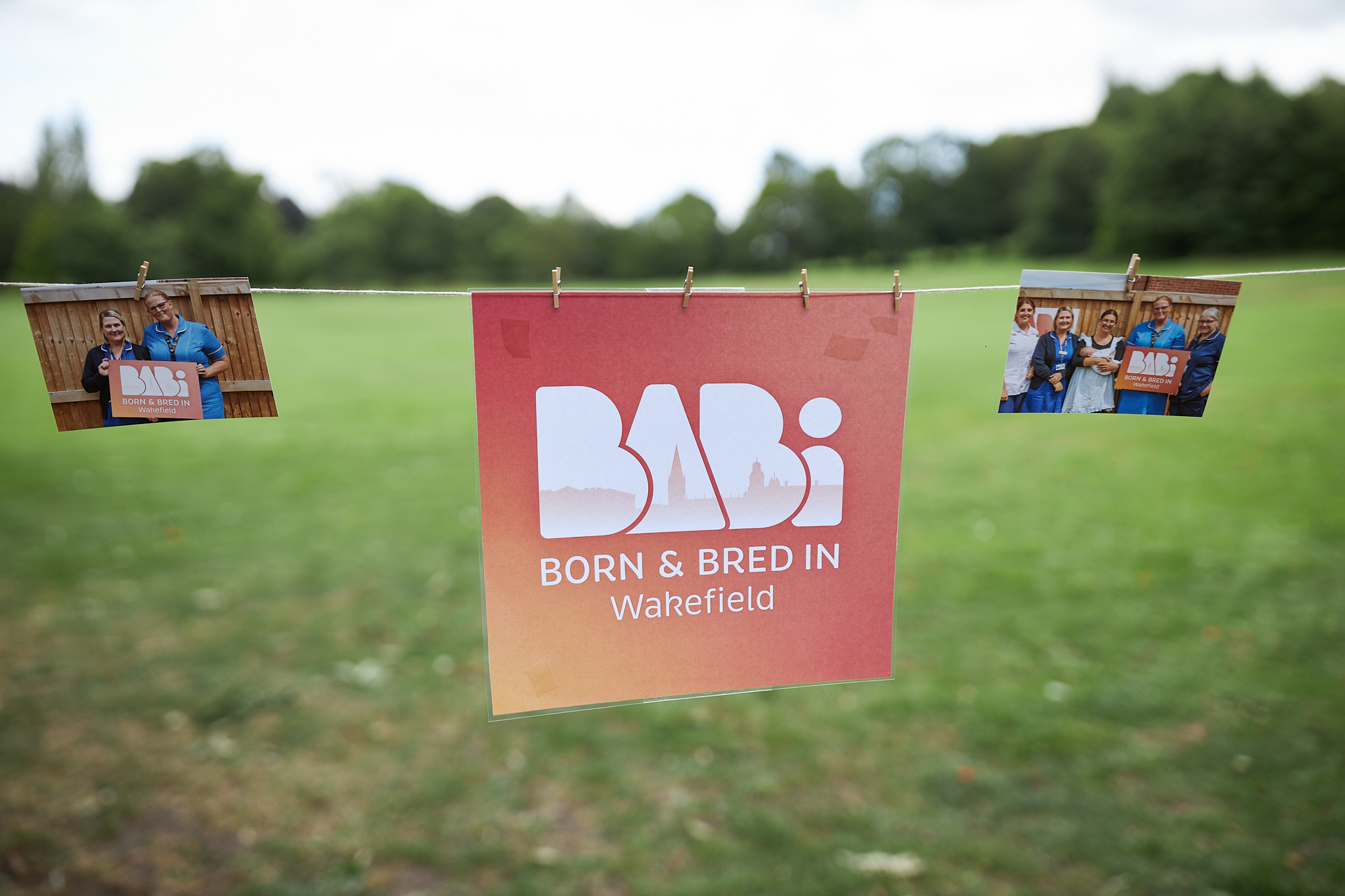 Image of two photographs and the BaBi Wakefield hung on some string with wooden pegs.